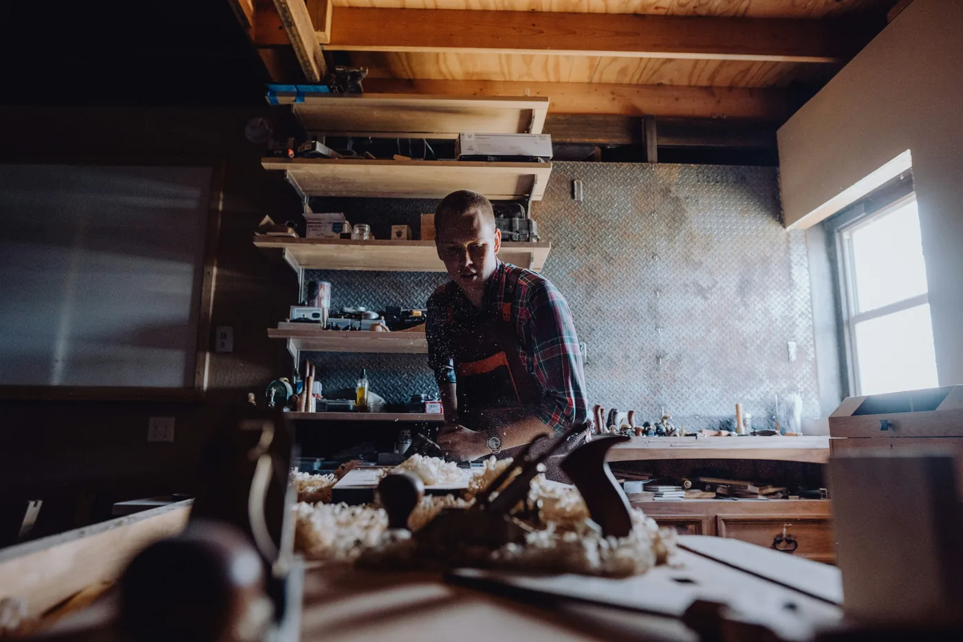 Illustrative photograph of a person working with wood in a workshop